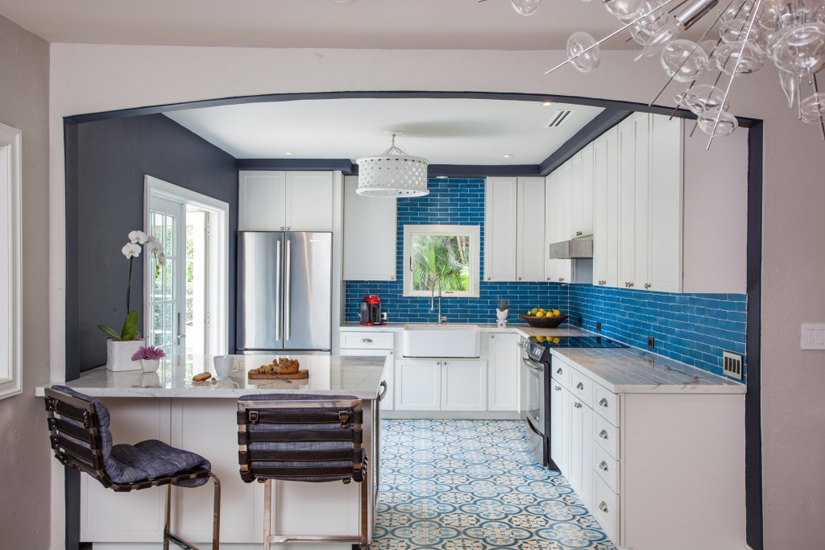 Small white kitchen with blue subway tile backsplash and vintage industrial bar stools