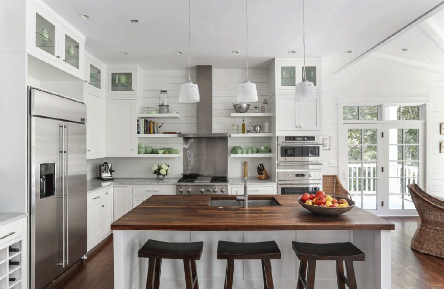 White kitchen with open shelves and saddle bar stools. Kitchen with mini dome pendant lights over kitchen island with wood countertops