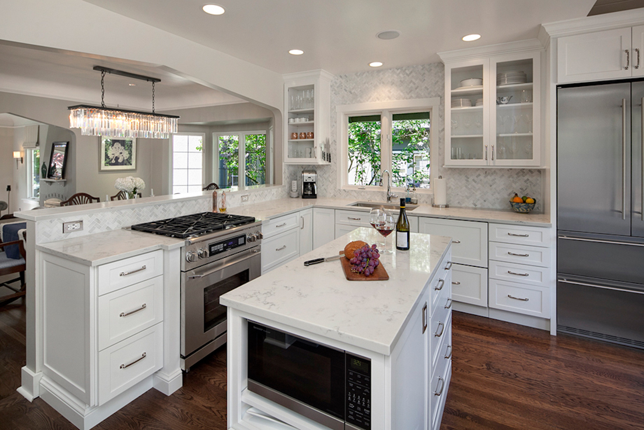Open concept white kitchen with harwood flooring and capiz shell chandelier 