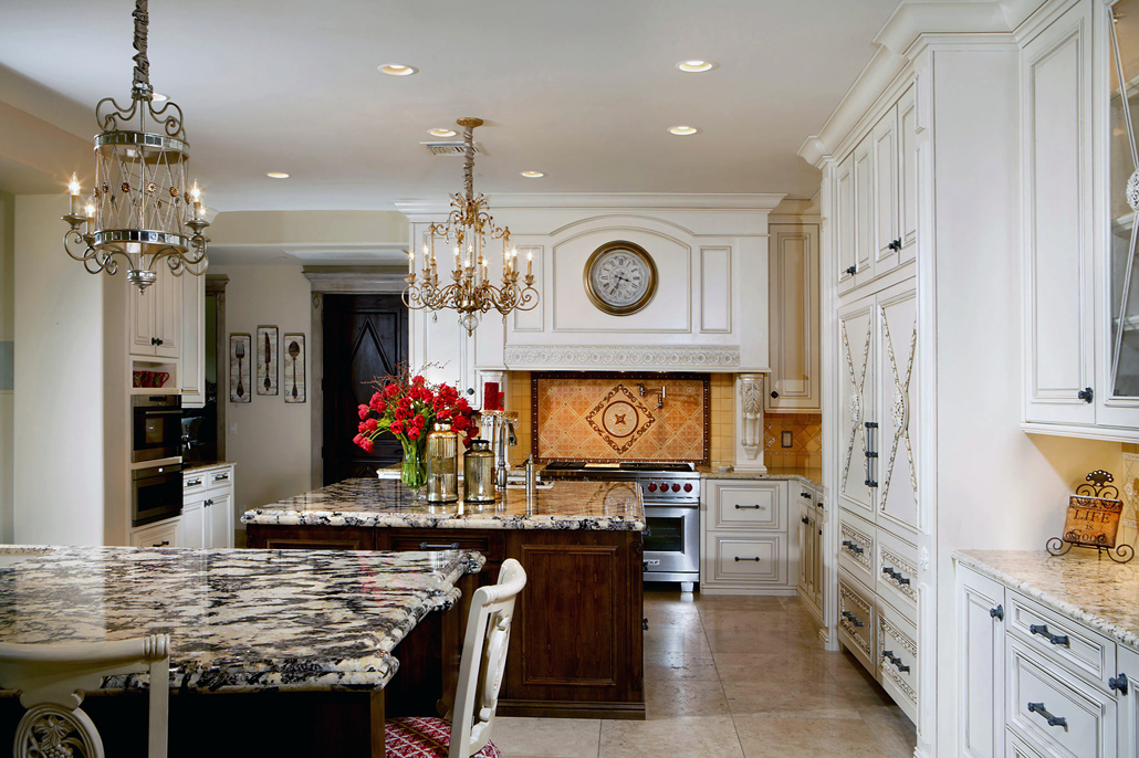 Traditional white kitchen design with candle chandelier over wooden kitchen island with granite countertops