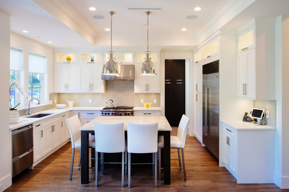 White kitchen with white leather bar stools. Kitchen with chrome pendant lights over kitchen island with laminate countertops
