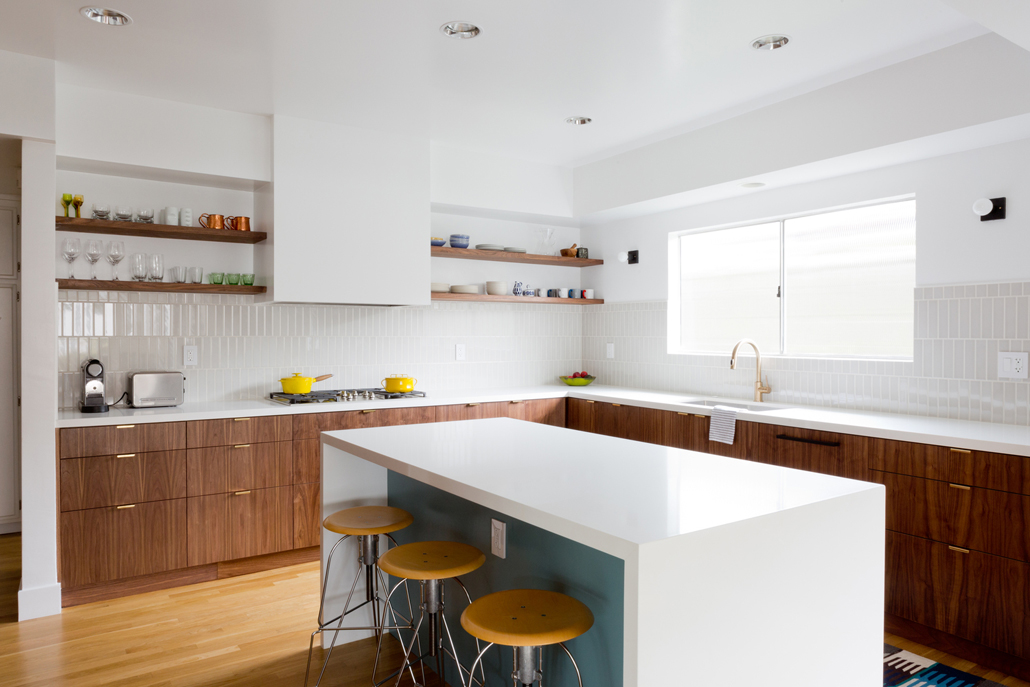 White kitchen with open wood shelves and backless bar stools 