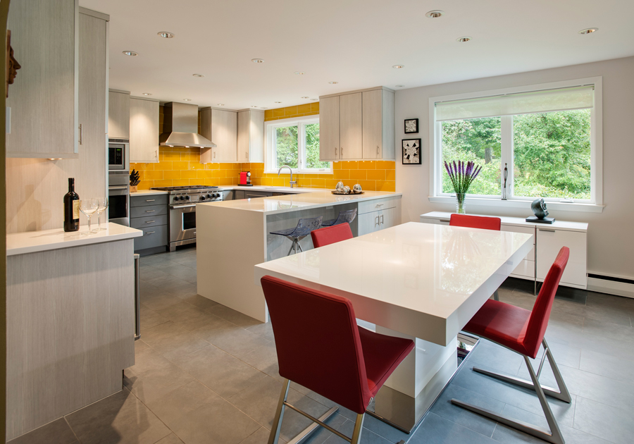 White kitchen with yellow subway tile backsplash and dining table with red chairs