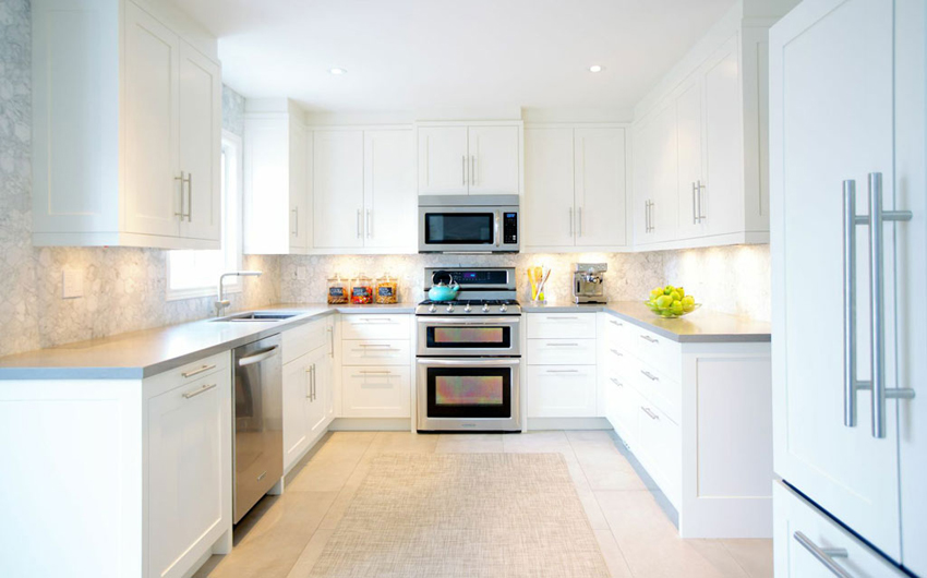Small white kitchen with white mosaic tile backsplash and under cabinet lighting 