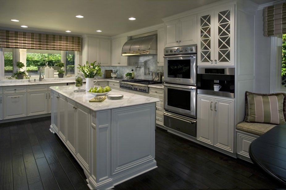 White kitchen with dark wood floors and white kitchen island with marble countertop 