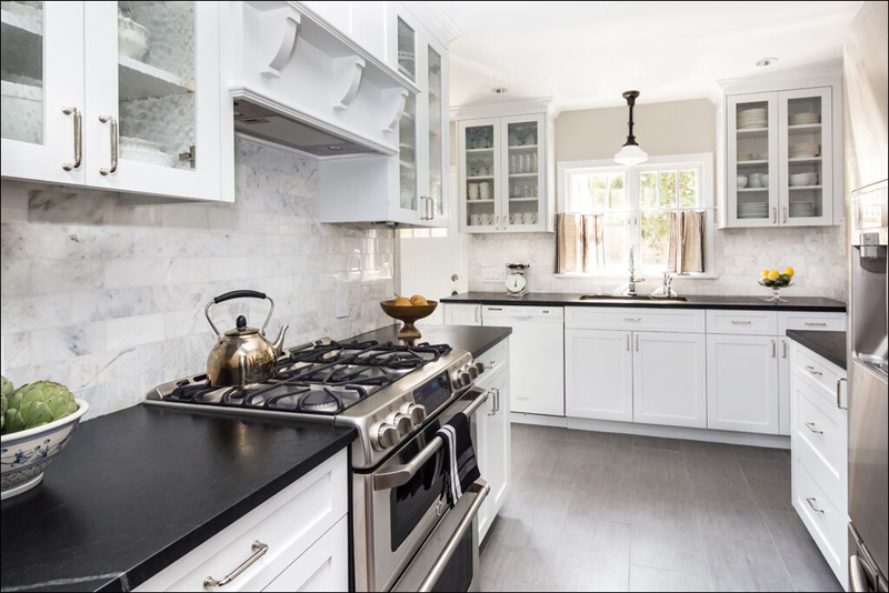 White kitchen with black quartz countertop and dark wood floors