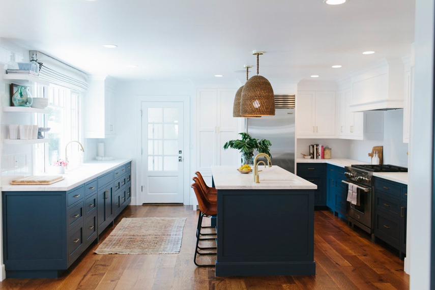 White kitchen with navy accents and hardwood floors. Kitchen with unique dome pendant lights over navy kitchen island with white laminate countertop