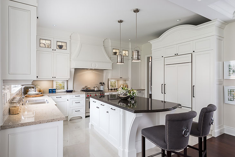 Classic white kitchen with vinyl flooring. Kitchen with chrome pendant lights over white kitchen island with black laminate countertop