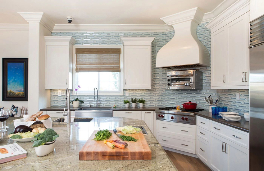 White kitchen with turquoise tile backsplash and dark quartz countertop