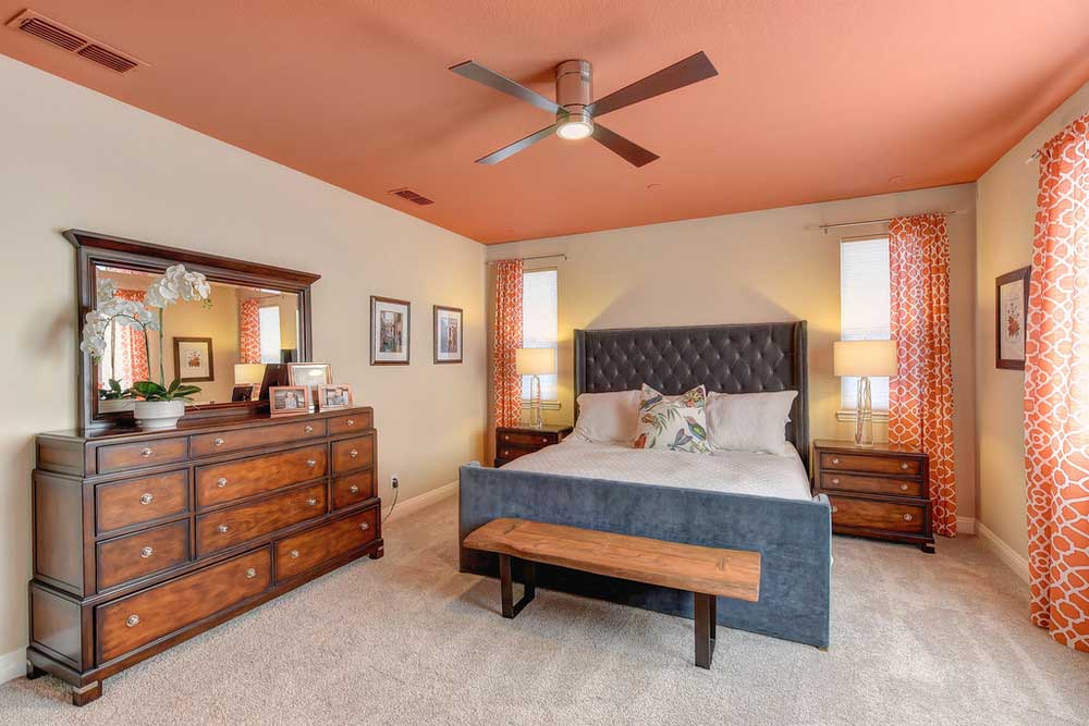orange bedroom with ceiling fan lighting