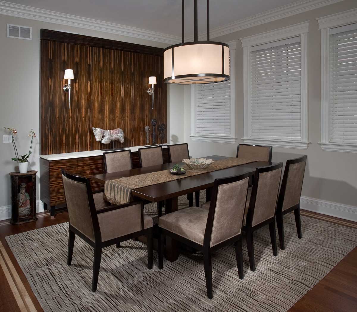 dining room with wall sconces and drum pendant light