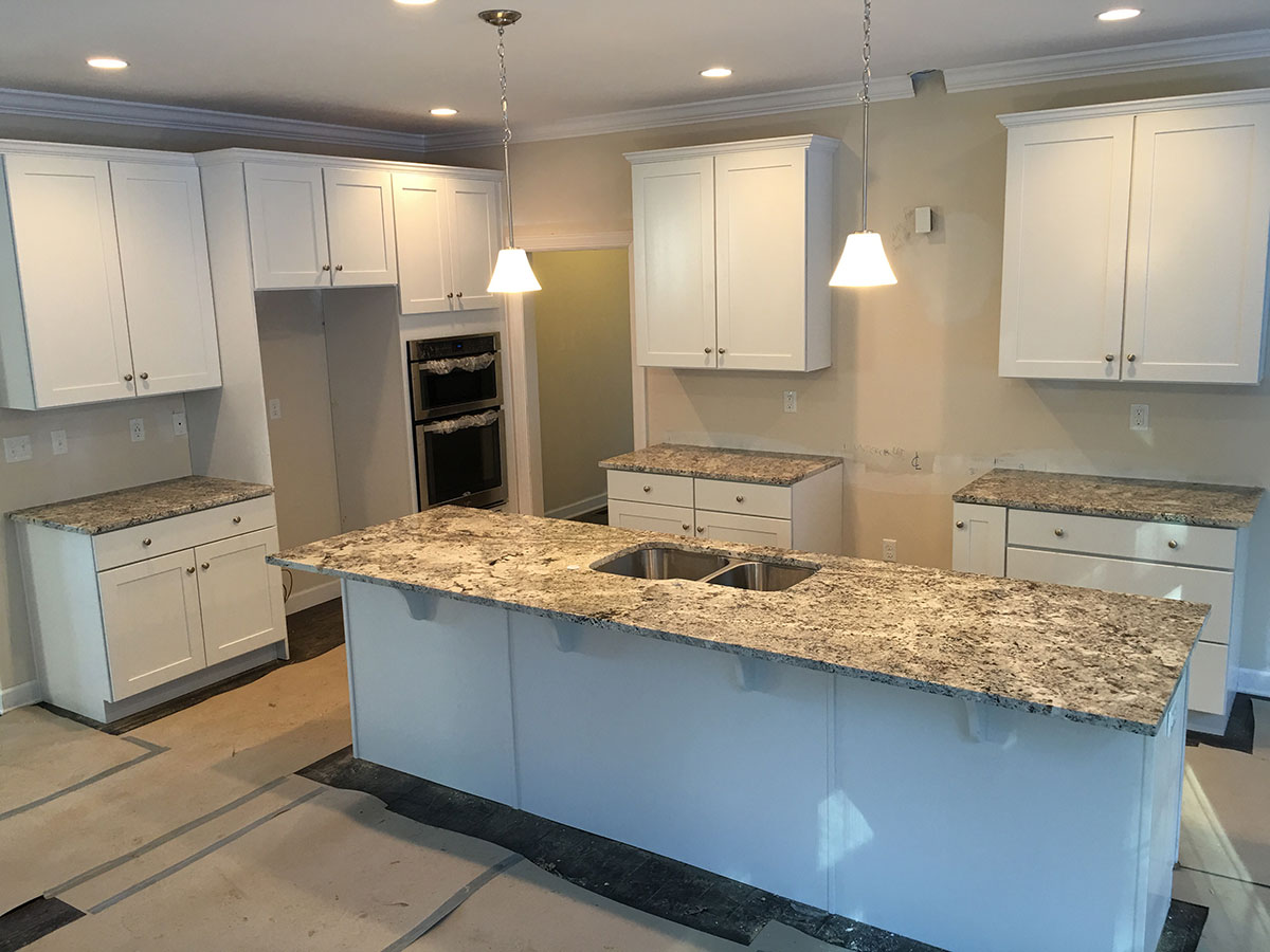 White kitchen with alaska white granite countertops