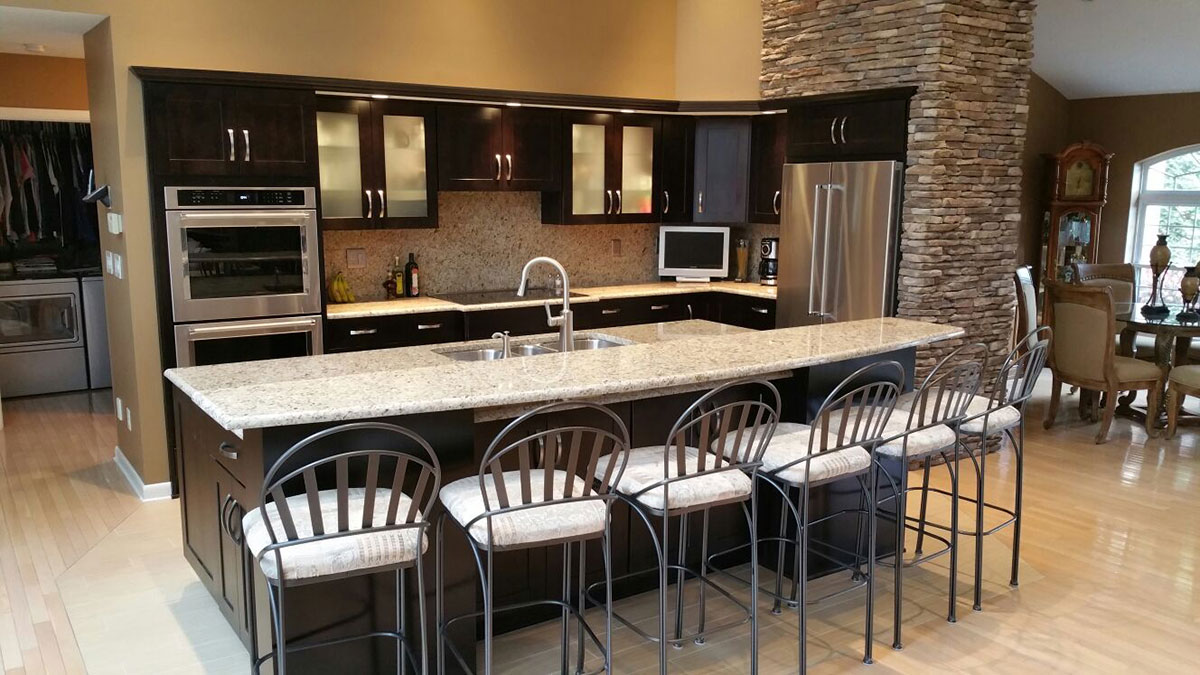 Black kitchen cabinets with white ornamental granite countertops