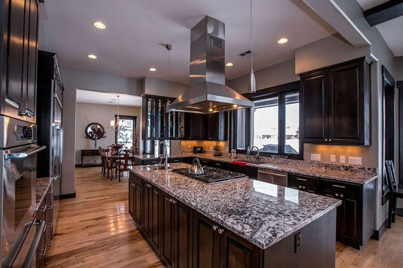 Dark kitchen cabinets and white wave granite countertops