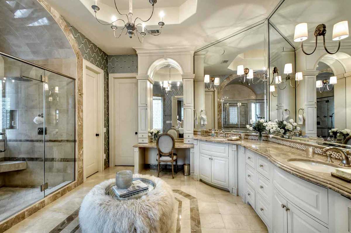 master bathroom with wall sconces and candle chandelier