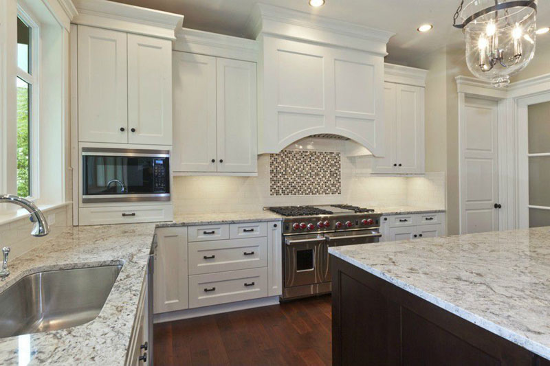 Traditional kitchen with bianco antico granite countertops and white cabinets