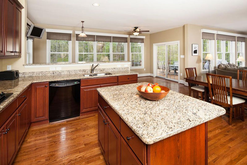 Open plan kitchen design with bianco antico countertops