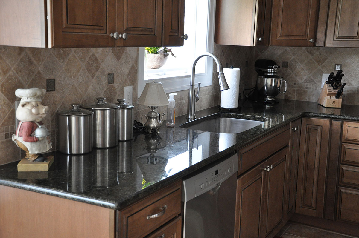 Dark brown cabinets with uba tuba granite