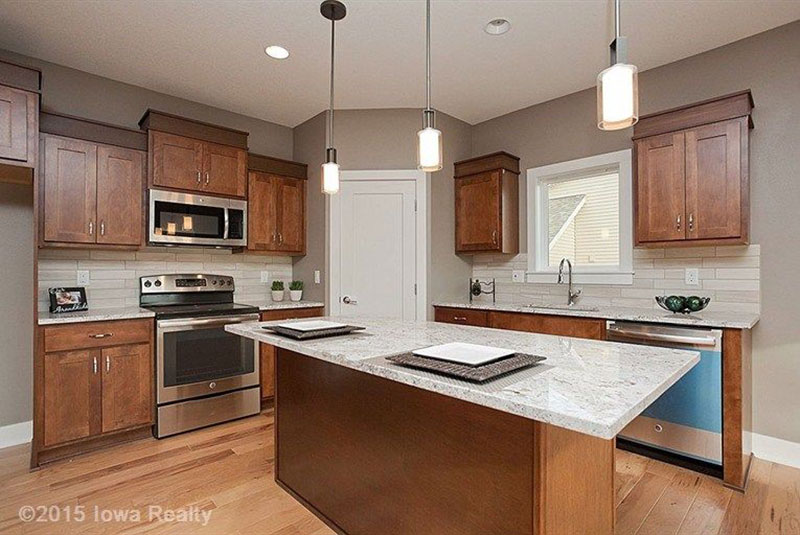 Wood kitchen cabinets with river white granite