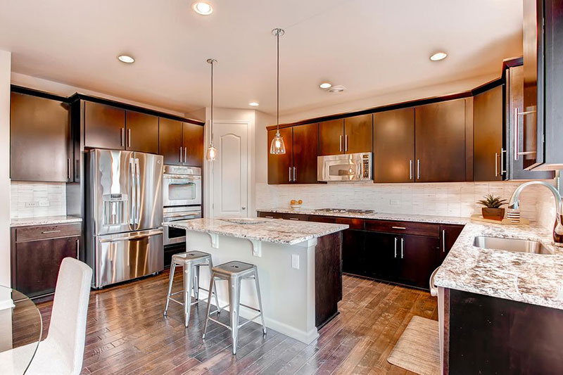 Contemporary kitchen design with bianco antico countertops and dark cabinets