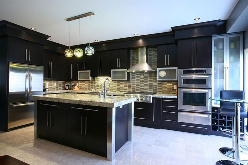 Black kitchen with bianco antico granite countertops with tile backsplash