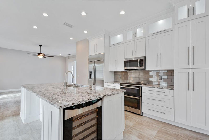 Modern white kitchen design with bianco antico granite countertops