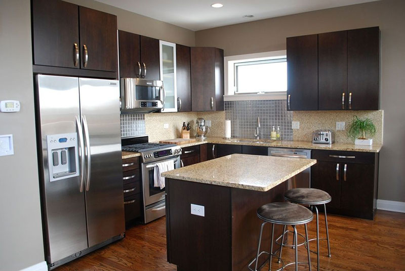 Contemporary kitchen with dark cabinets and bianco romano granite