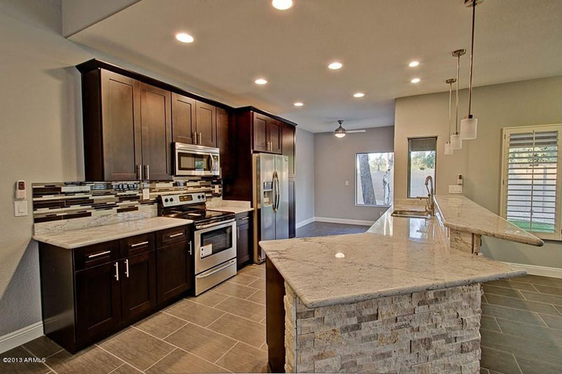 Black kitchen cabinets with bianco romano granite